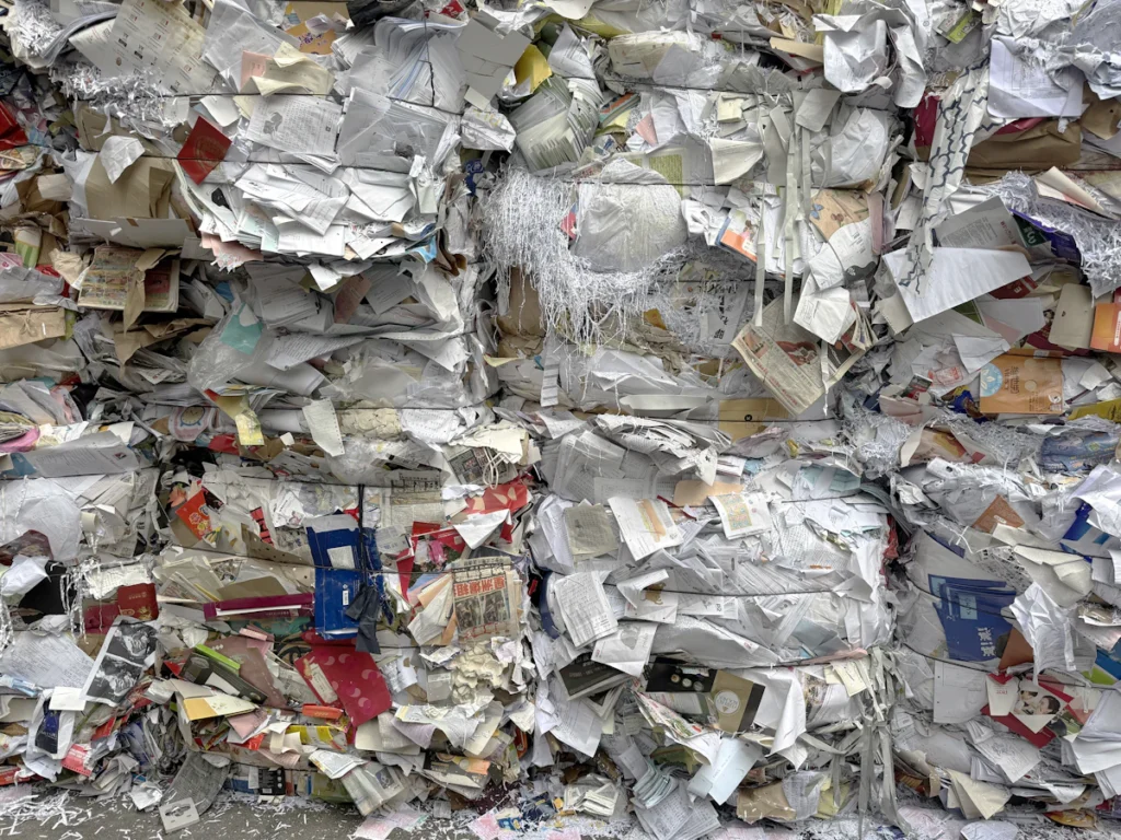 Pacas de papel y cartón aprovechable compactadas en el centro de acopio