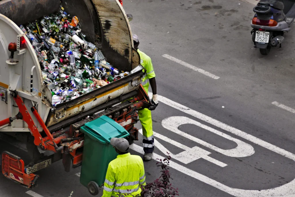 Recolección de residuos con camión y contenedores en la calle